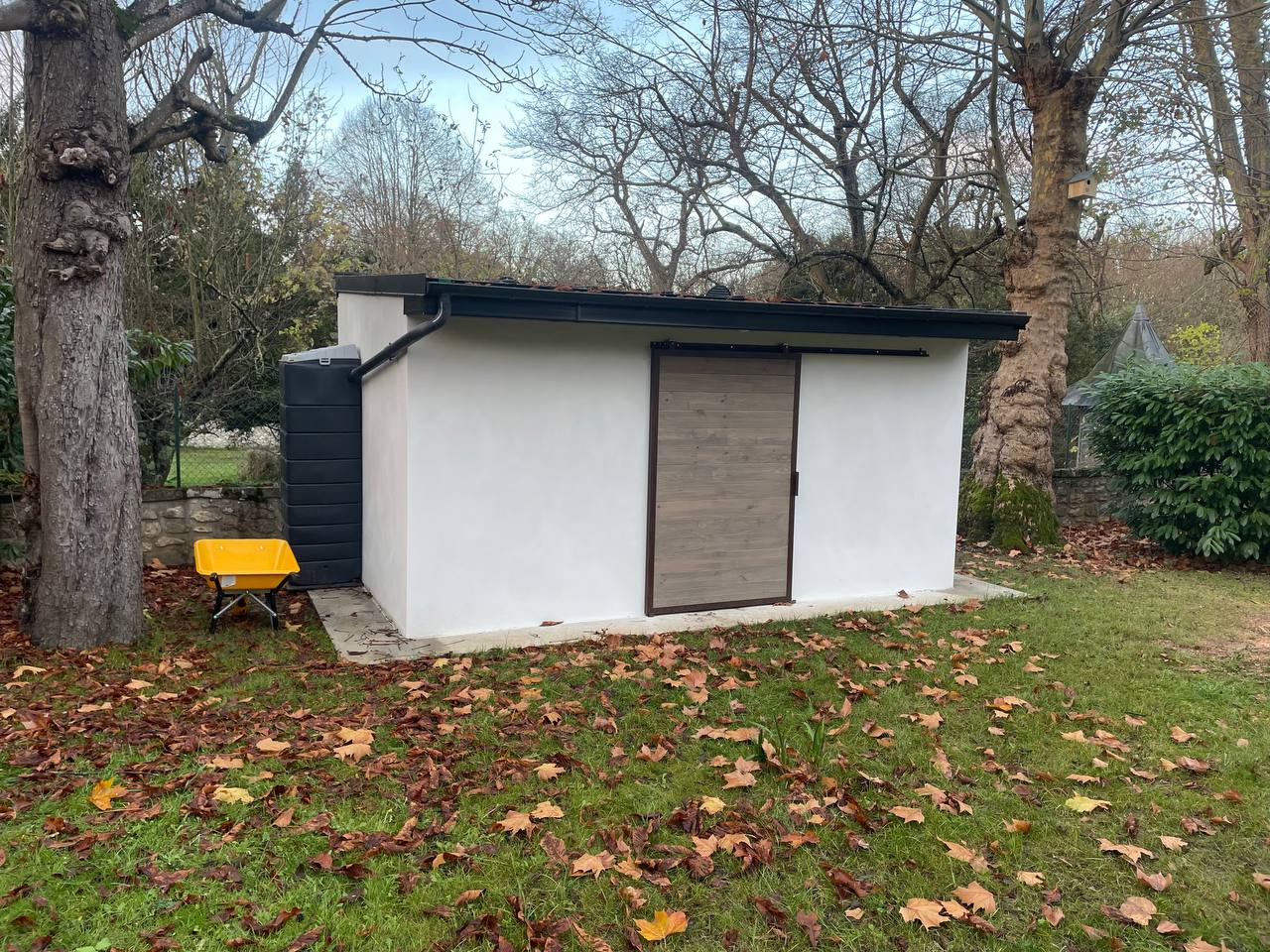 Abri de jardin terminé avec enduit blanc et bardage bois