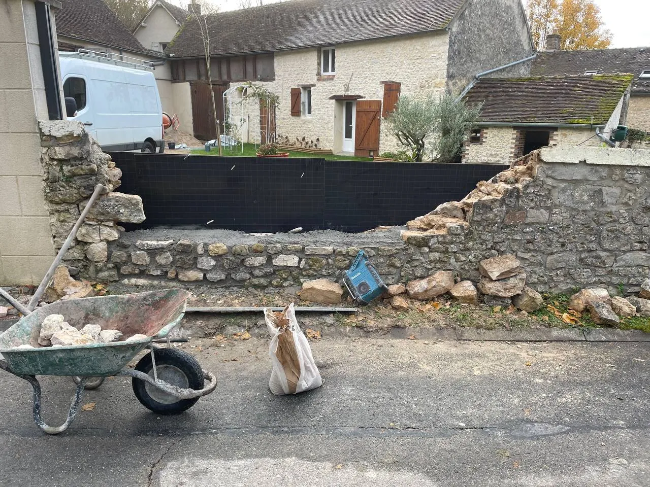 Mur en pierre partiellement effondré avec gravats